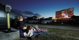 The Hinesley kids — from left, Anndee, 14; Alec, 6; and Aidan, 9 — watch the movie “WALL-E” from the comfort of a sleeping bag and blankets beneath a perfect evening sky at the Huntington Drive-In Theatre last month. Mom and dad, Trace and Dee, watched from the car beside them. The Hinesleys, of rural Huntington, are members of United REMC.
