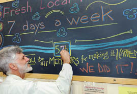Andy Mahler, chair of the Lost River board of directors, chalks up a new member at the market and deli in Paoli last month. Mahler was one of the organizers of the consumer co-op. He is also a member of Orange County REMC.