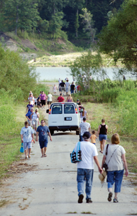 As if on a pilgrimage, visitors make their way to and from what once was Monument City on the edge of the Salamonie reservoir Aug. 5. Though exposed in winter, the old town site and this portion of road are usually under water in summer. The Indiana Department of Natural Resources hosted two Sunday evening “homecomings” at the site in response to public interest after it became exposed by the drought-lowered lake.