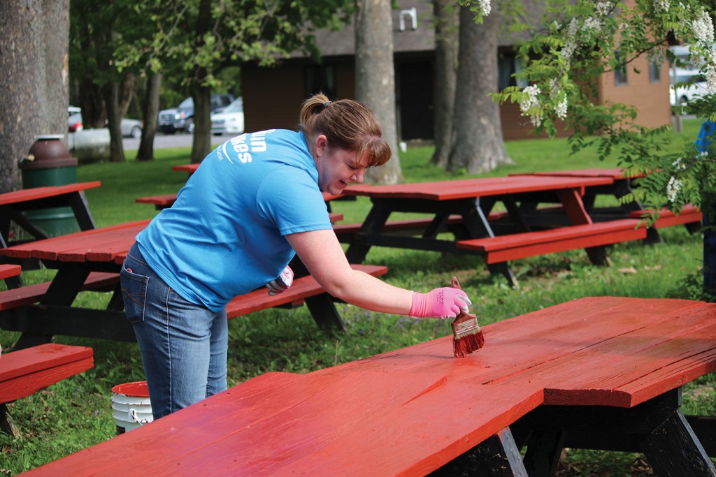 Traci Mountcastle, member service representative and Community Day chairperson, paints picnic tables. 