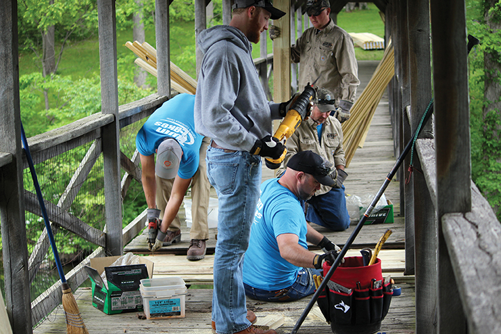 Tipmont employees work on redecking a covered bridge.