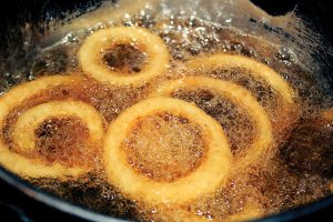 Onion Rings cooking in hot bubbly oil in a deep fryer