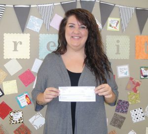 Courtney Gant, regional coordinator of The Crossings Educational Center, receives an Operation Round Up grant of $2,000.