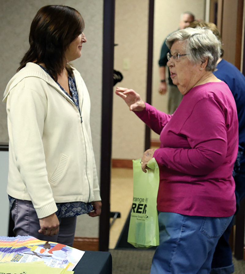 Orange County REMC’s Carla Piper, left, speaks with a member who just picked up a free Farmers’ Almanac and a copy of the Cooperative Calendar of Student Art, which is illustrated by students all over the state.