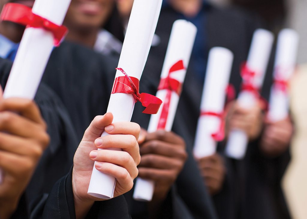 group of multiracial graduates holding diploma