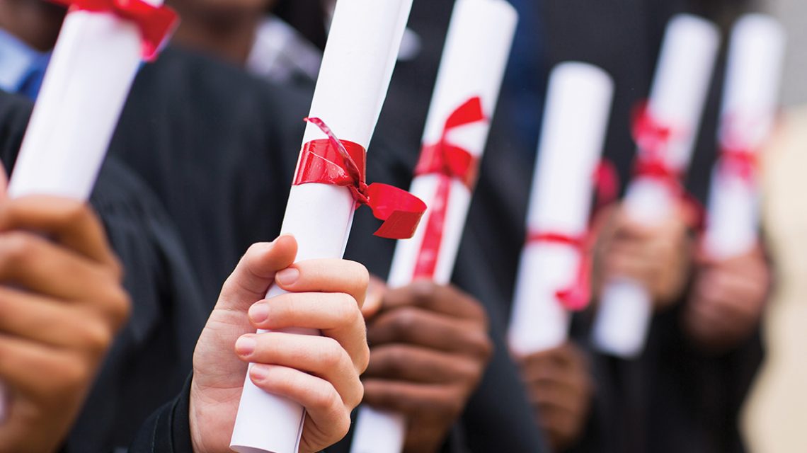 group of multiracial graduates holding diploma
