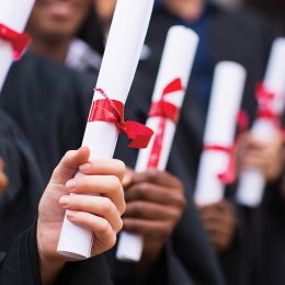 group of multiracial graduates holding diploma