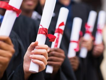 group of multiracial graduates holding diploma