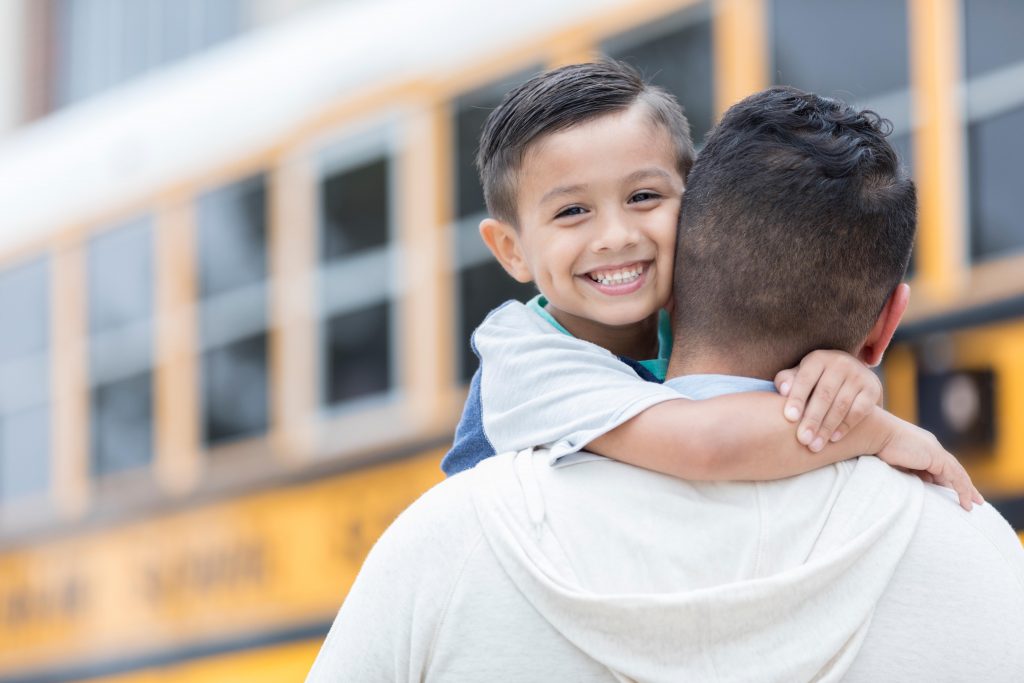 Child with dad getting on bus