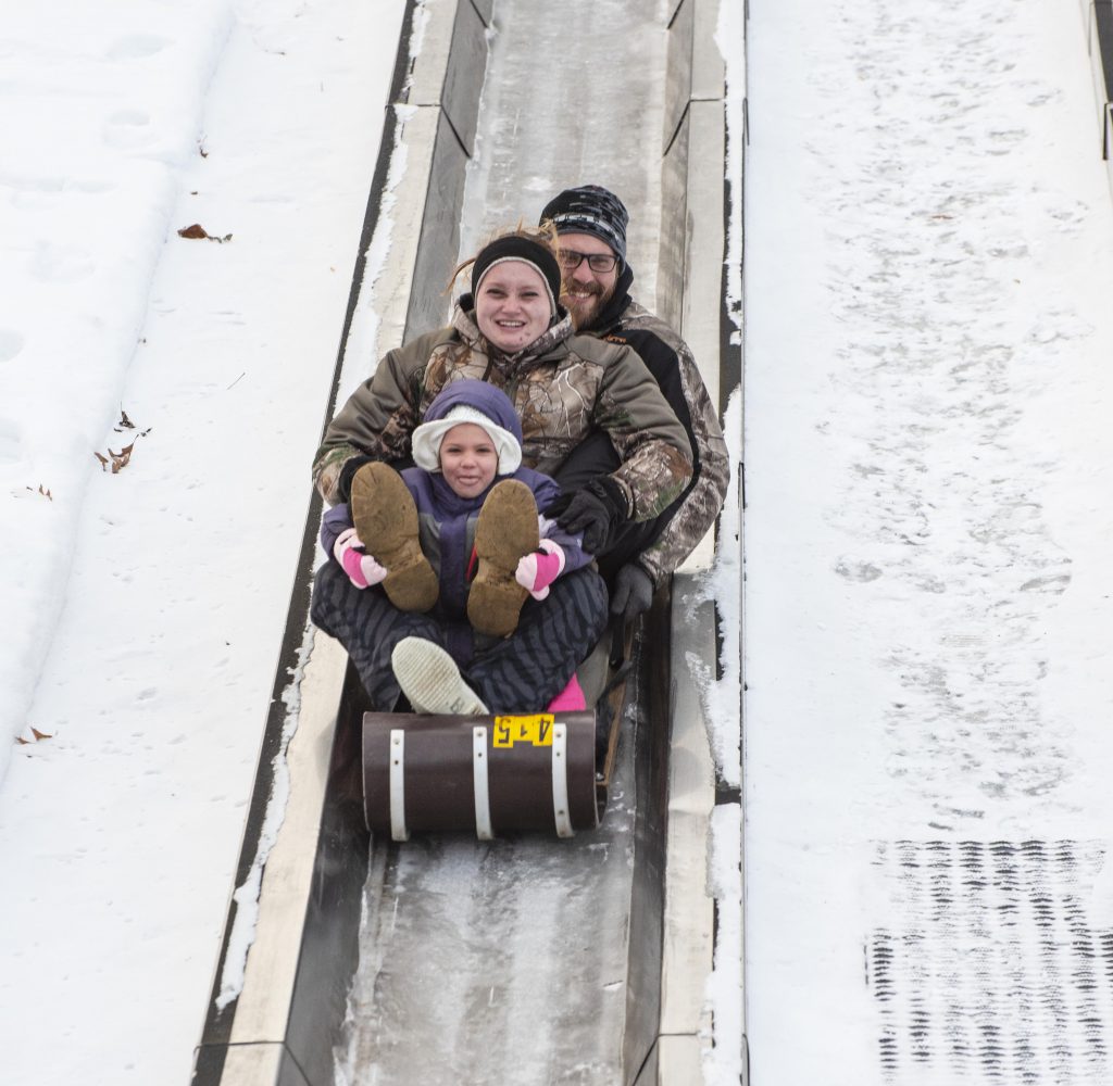 Family sliding down toboggan run at Pokagon State Park