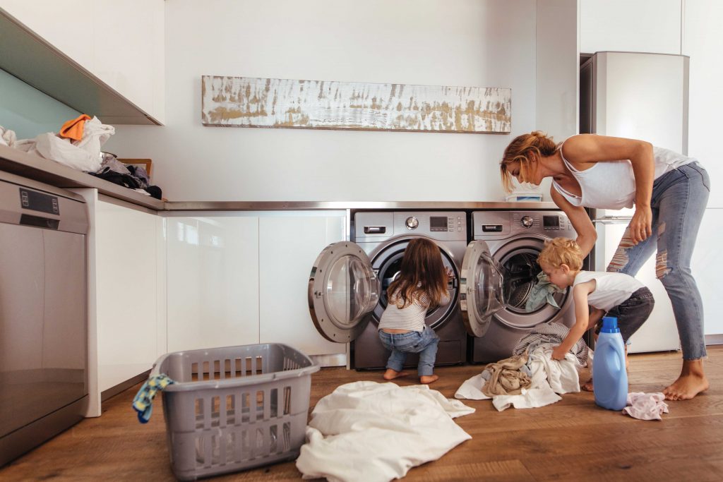 Woman doing laundry with children