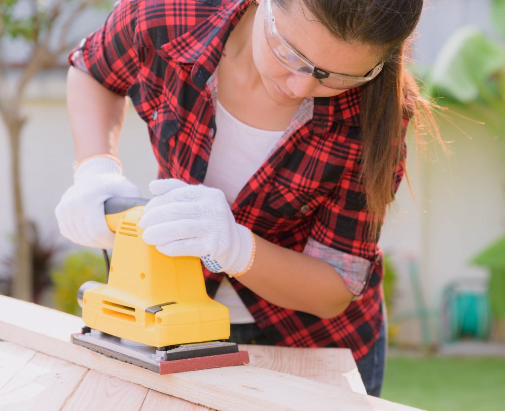 Woman with a power sander