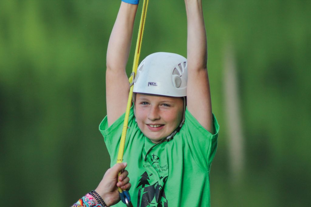 Young girl ziplining at camp