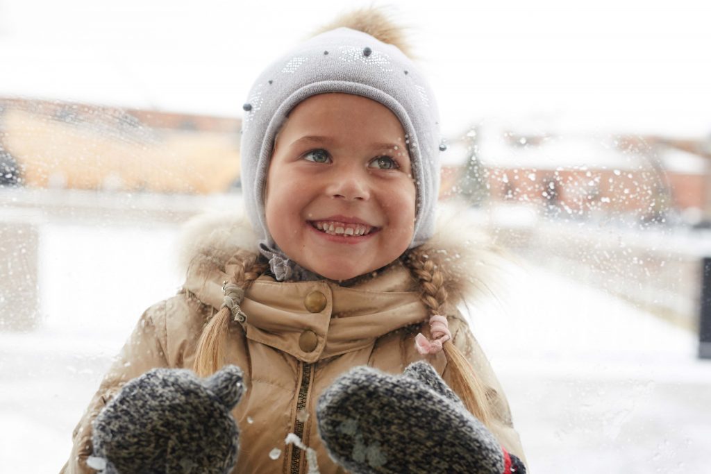KId in winter scene with mittens