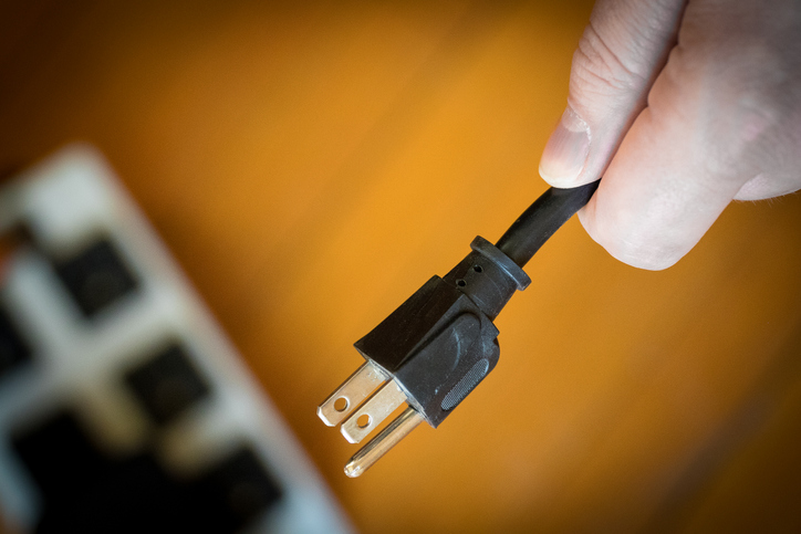 Photo of someone unplugging a power cord