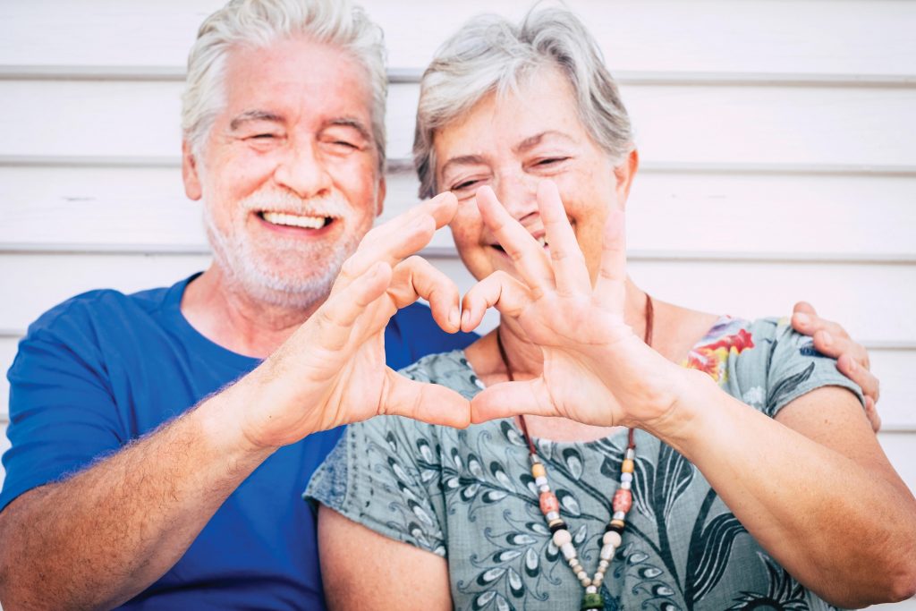 Photo of couple making a heart with hands