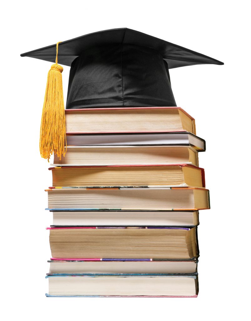 Photo of graduation cap on top of books