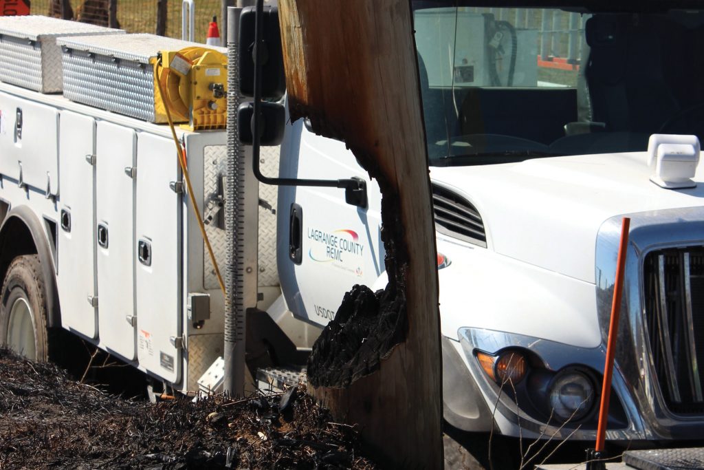 Picture of burnt pole in front of utility truck