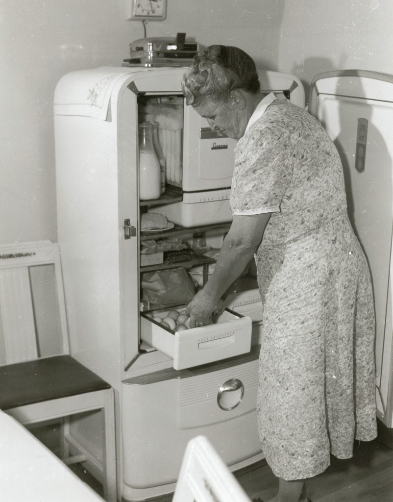 Woman using electric refrigerator