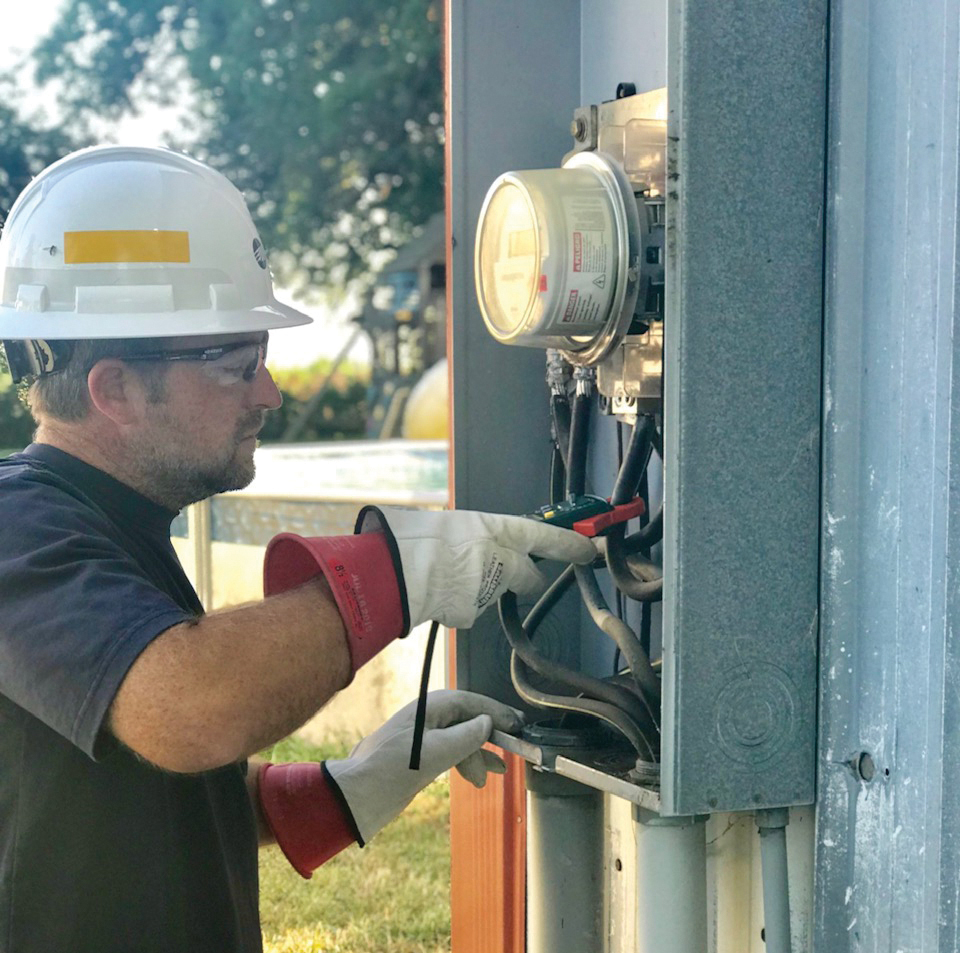 Employee checking an electric meter