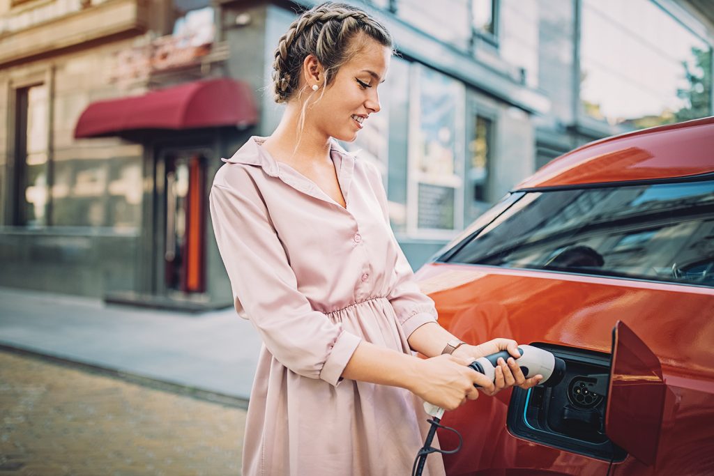 Woman plugging in electric car