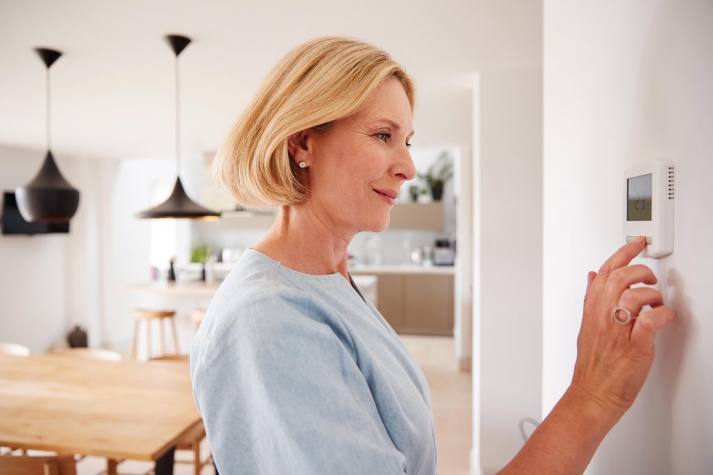 Woman setting thermostat