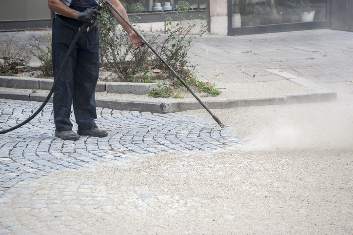 Man pressure washing a driveway