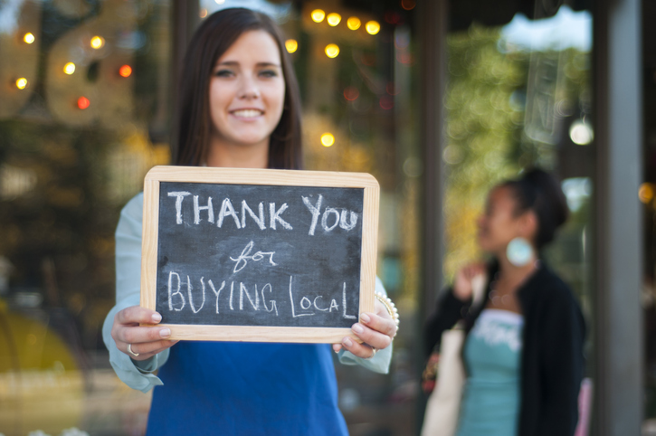 Woman holding buy local sign