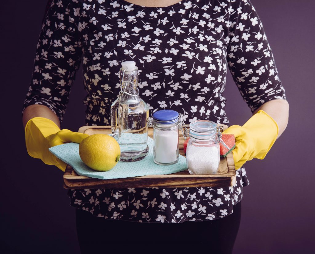 Woman holding natural cleaning products.