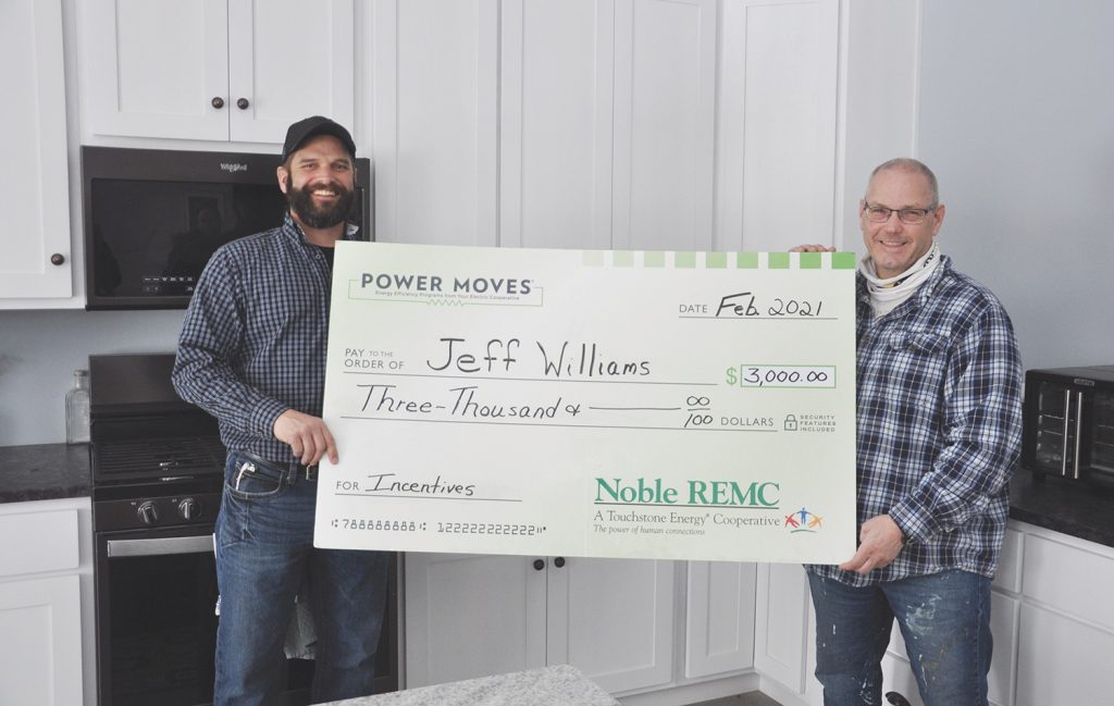 Noble REMC Energy Advisor Brian Hawk, left, presents a Power Moves incentives check to homeowner Jeff Williams.