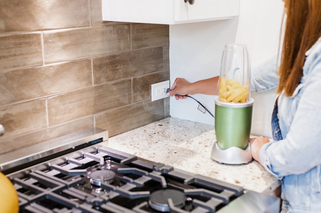 Woman plugging an appliance into a receptacle