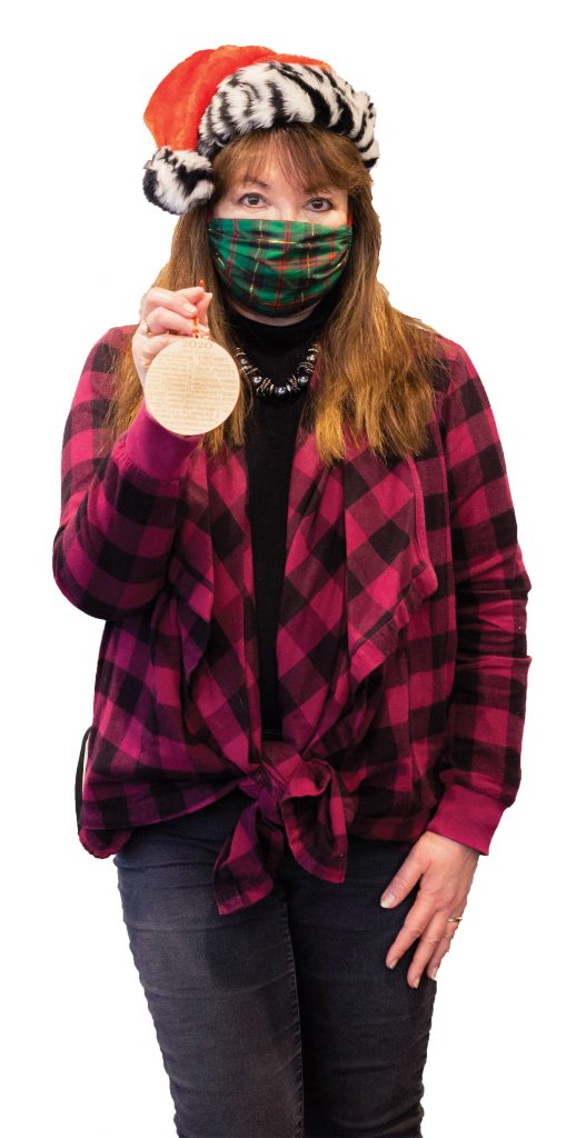 Em in mask holding Christmas ornament