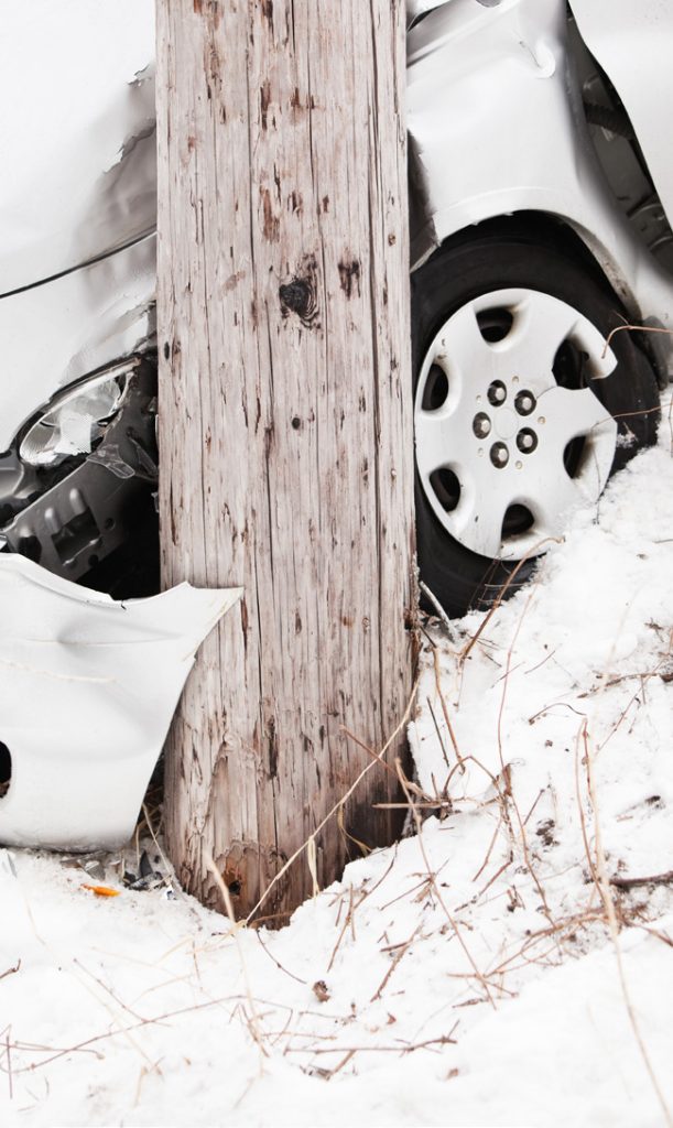Car wreck in snow with utility pole