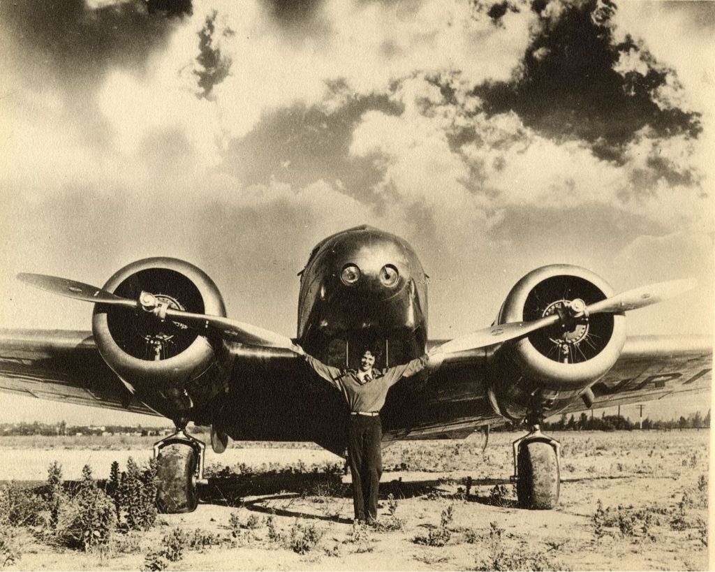 Amelia Earhart in front of a plane