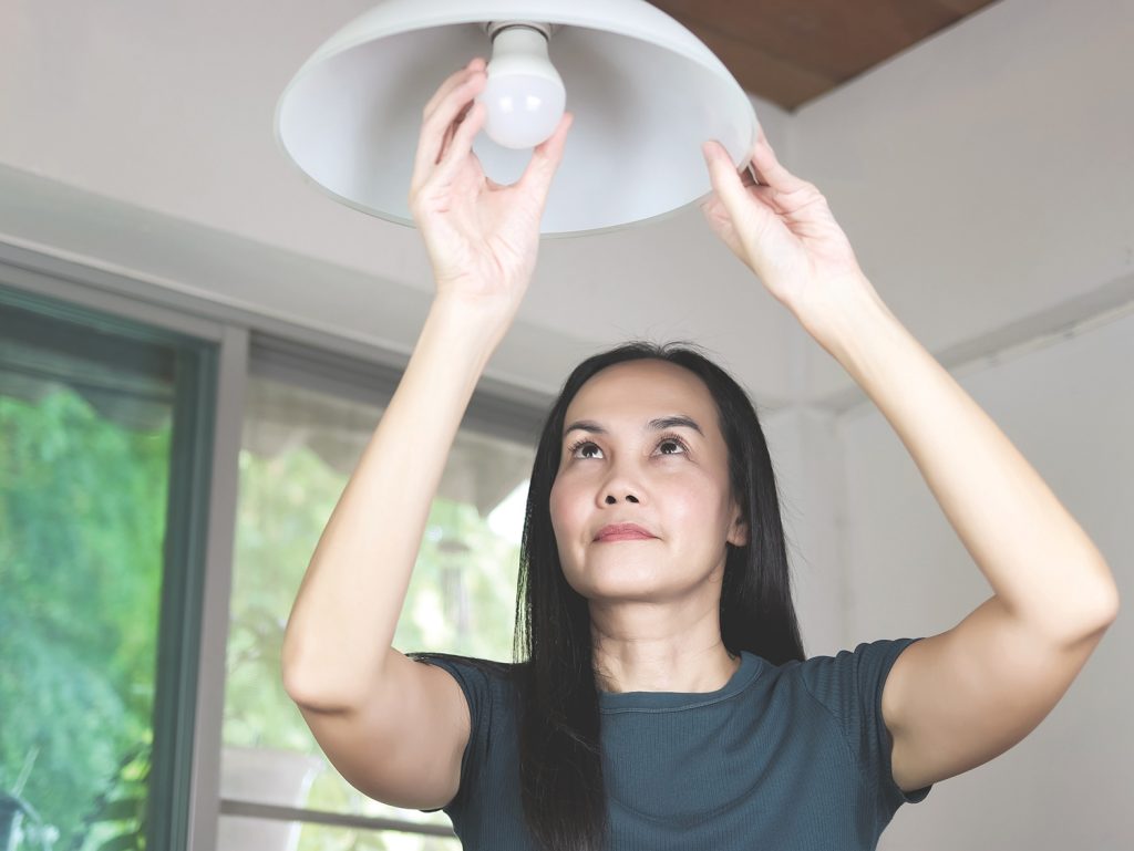 Woman changing lightbulb