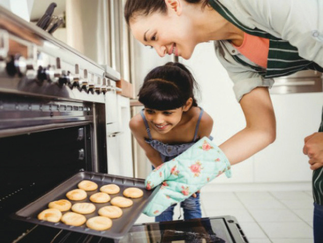 Woman and daughter baking cookies