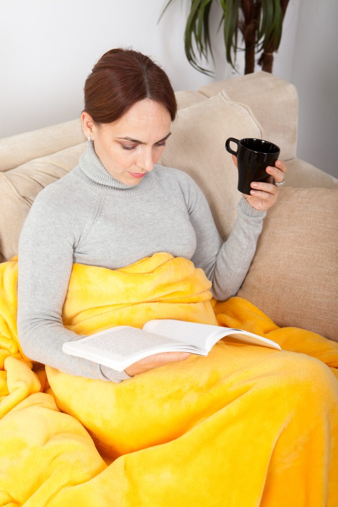 Woman drinking coffee with blanket