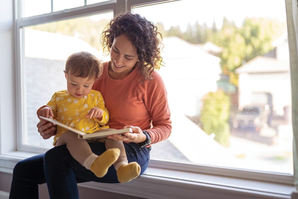 Woman and baby sitting in window sil