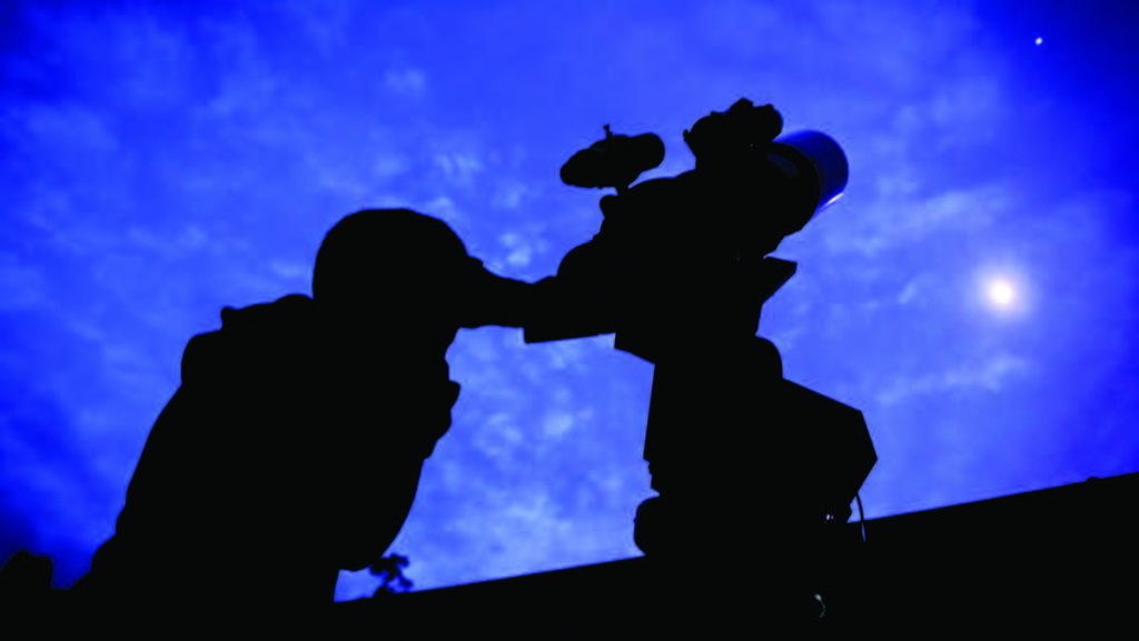 Person looking through telescope