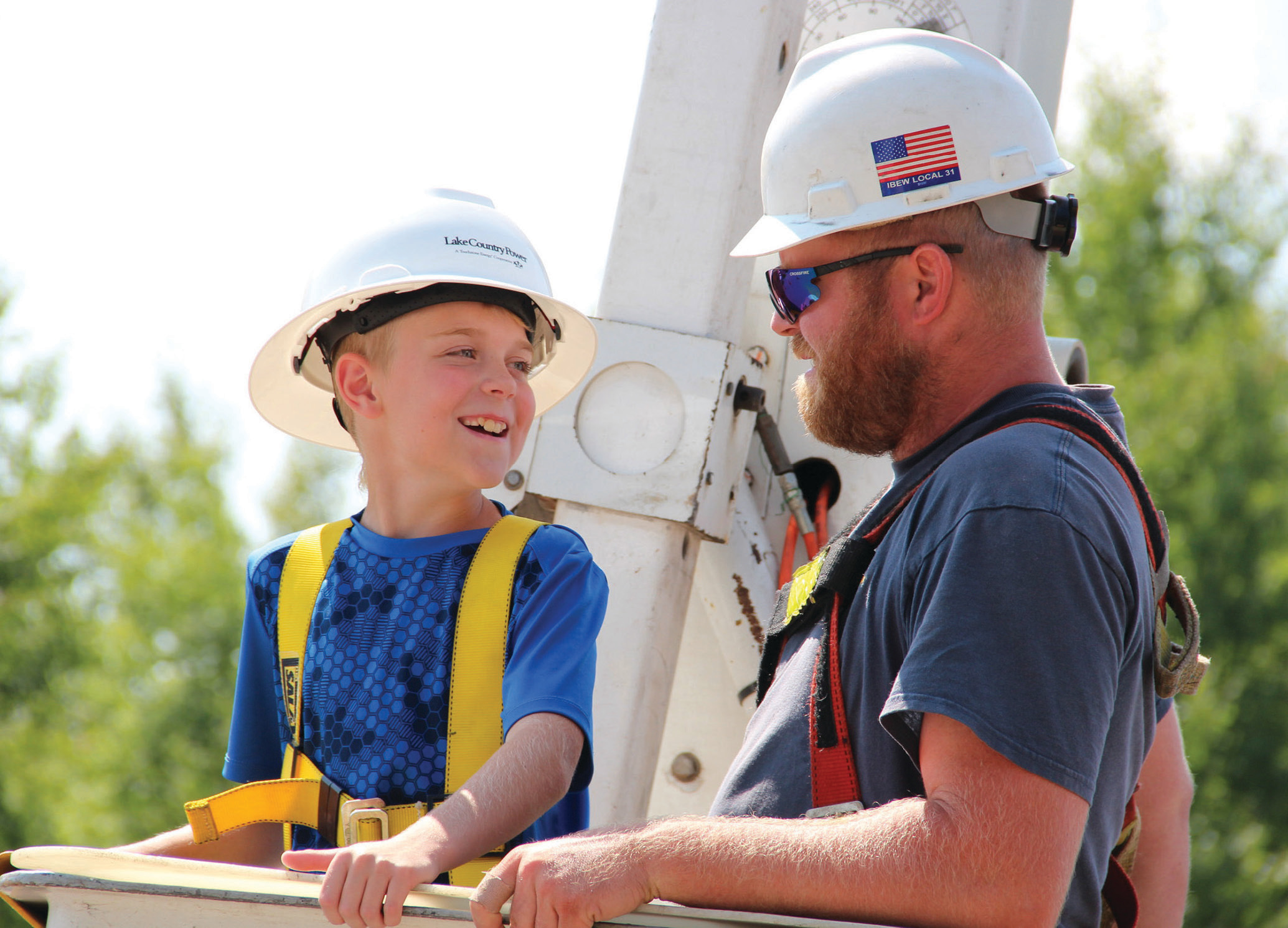 Lineman with kid in bucket truck