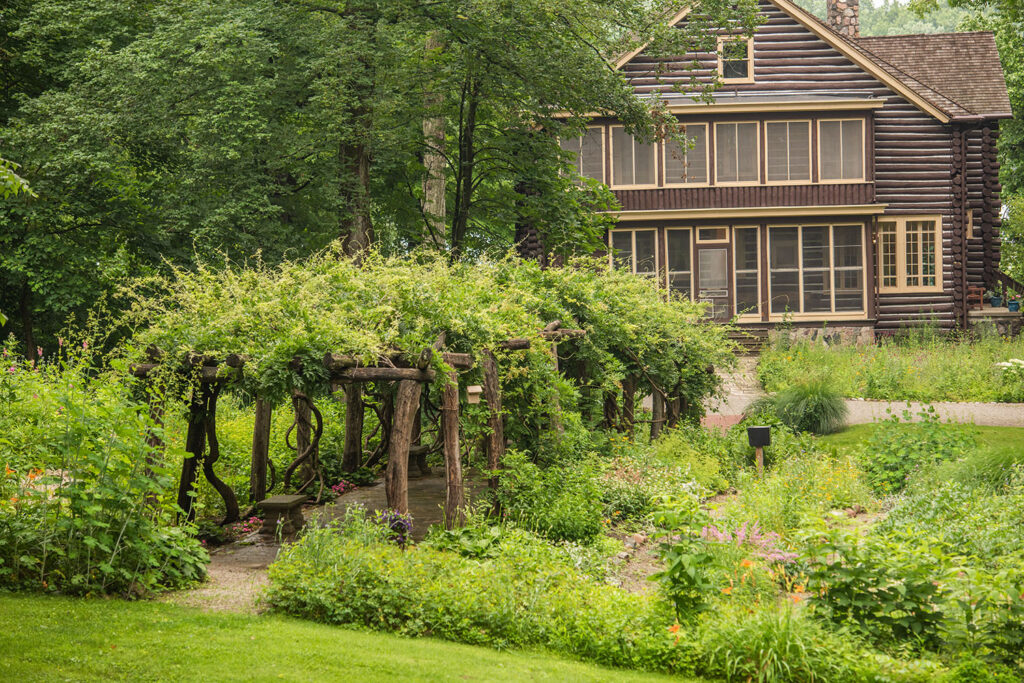 A wisteria-covered pergola stands amid a one-acre garden at Wildflower Woods, one of the highlights of the site’s wooded paths and more than three miles of trails.