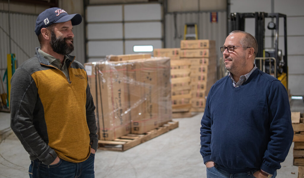 Among the Indiana businesses that have benefited from electric cooperative support is Three Birds Casual, a luxury furniture-making business in Noble County. Discussing energy-saving strategies are Noble REMC Energy Advisor Brian Hawk (left) and Three Birds Casual President Tad Varga.