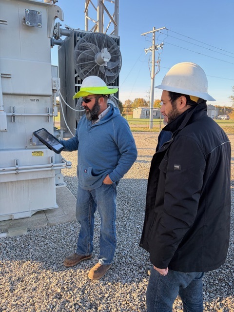 While on the job at a substation, Hoosier Energy Substation Working Foreman Jared Bartlett, left, and GIS/EAM Coordinator Jason Santana access GIS information on an iPad.