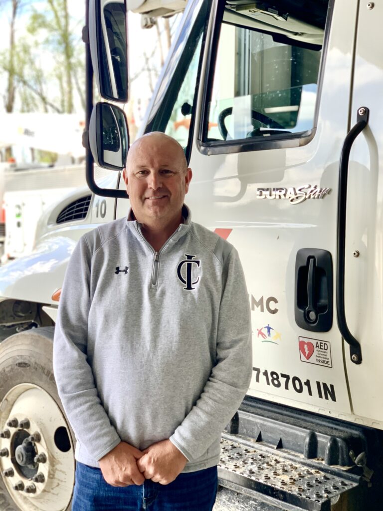 Justice stands with a KREMC Truck.