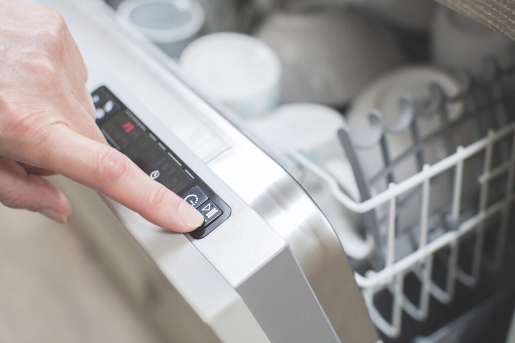 Woman. starting dishwasher