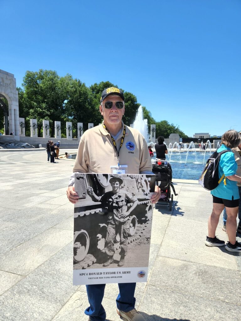 Ron Taylor in Washington, D.C., holding a picture of himself from his time of service.
