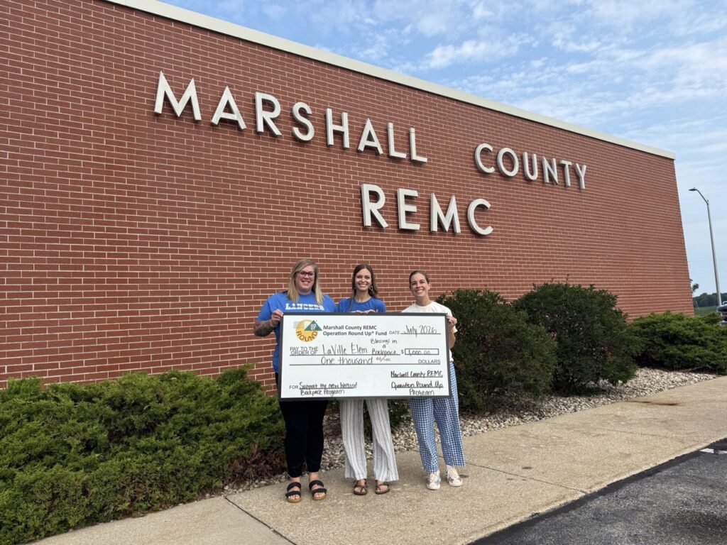 Representatives from LaVille Elementary’s Blessings in a Backpack program stand with a $1,000 check donation from the Operation Round Up program.