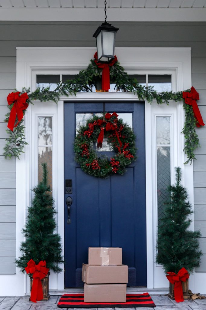 House decorated for holidays with packages in front of door
