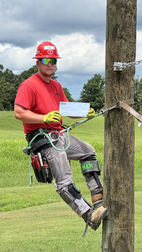 Logan Englert with his scholarship award at the North American Lineman Training Center.